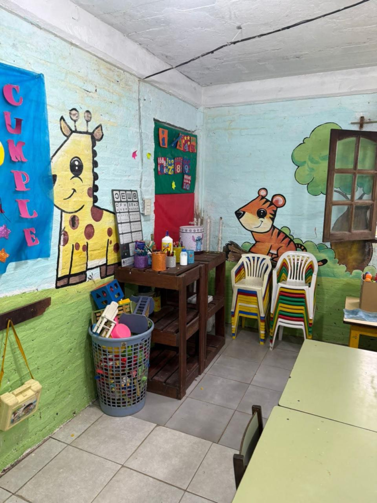 Sala del jardín de infantes de la Escuela N.º 797 de Isla Soto, con murales de animales, mesas, sillas y materiales didácticos